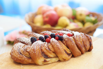 Apple pie decorated with fresh berries on a blurred background. Bokeh.