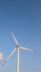 Vertical view of electric turbines with blue sky background.