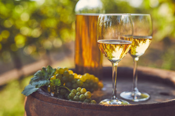 Two glasses of white wine on a wooden barrel