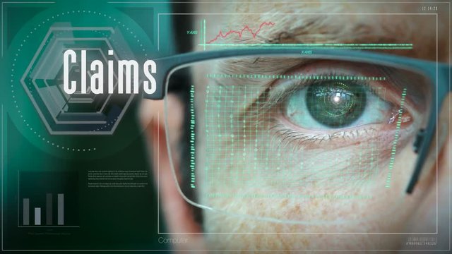 A close up of a businessman eye controlling a futuristic computer system with an Claims concept.