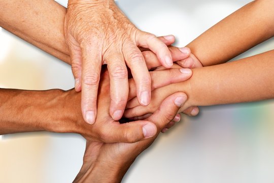 Close-up view of group of people stacking hands
