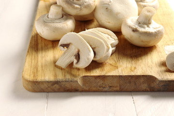 Sliced champignons on wooden cutting board, closeup