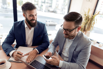 Two young businessmen discussing at meeting