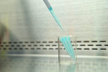 The researcher using pipette and splitting pipette tip from pipette in the lab test.