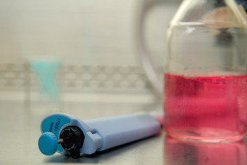 Pipette and medium culture bottom liquid in the background.