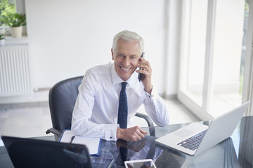 Confident businessman making call and getting good news