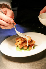 chef preparing fish goujon with chipped potatoes and pea puree
