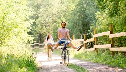 Fotobehang cycling, leisure and lifestyle concept - happy young couple with bicycles at summer park © Syda Productions