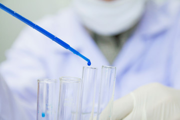 Close up. Medical or male medical in laboratory room research performs tests with blue liquid, Experimental Drug Treatment