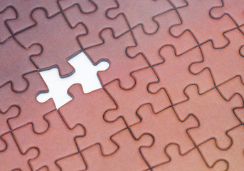 Fototapeta premium Concept image of one piece missing on a puzzle on a white surface.