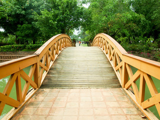 Fototapeta na wymiar Wood bridge across the water in the park.