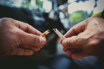 Cigarette being broken in two pieces by man stop smoking stop addiction