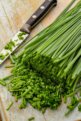slicing fresh chives on chopping board