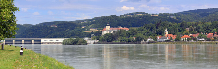 Panoramic view of the town of Persenbeug with the medieval Persenbeug castle and hydroelectric power plant from the opposite bank of the Danube river. Persenbeug, Lower Austria, Europe.