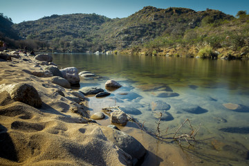 Long exposure taken in Cordoba, Argentina, in the lakeshore to show the silky and transparent water with branches and rocks beneath its surface
