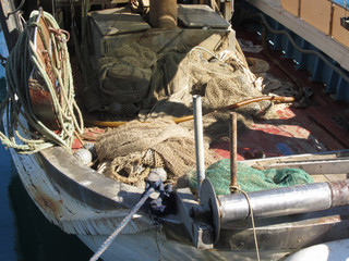 Fishing boat with fishing nets moored in the harbor . Tuscany, Italy