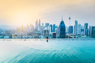 Crédence de cuisine en verre imprimé Kuala Lumpur Homme d& 39 affaires asiatique se détendre dans la piscine sur le toit derrière la belle vue sur la ville kuala lumpur dans le ciel du lever du soleil, Malaisie
