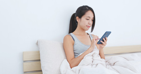 Woman use of mobile phone on bed