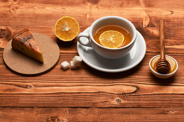 Tea cup with honey and cake making cozy composition