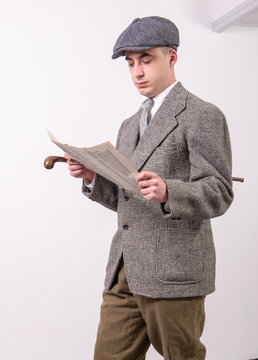 Young Man In Vintage Clothes With Hat, Reading Newspaper, 1940 Style