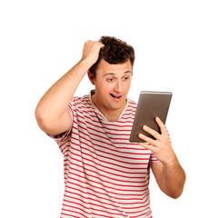 Young shocked student working on a digital tablet. emotional guy isolated on white background