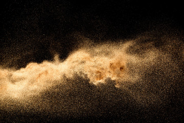 Fototapeta na wymiar Dry river sand explosion. Golden colored sand splash agianst dark background.