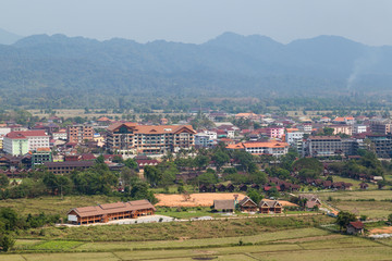 Fototapeta na wymiar Hotels in downtown Vang Vieng viewed from above on a sunny day in Laos.