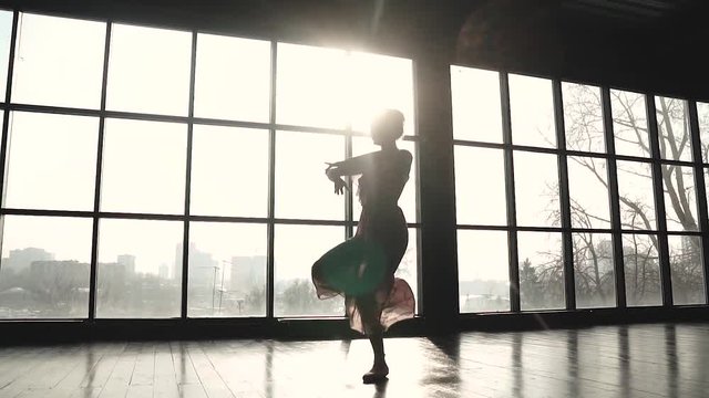 ballerina in pointe shoes and long fluttering dress makes pirouette. slow motion