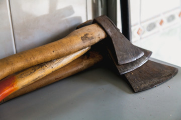 Three axes lie in pile on shelf
