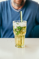 tall glass with a cocktail is on the table