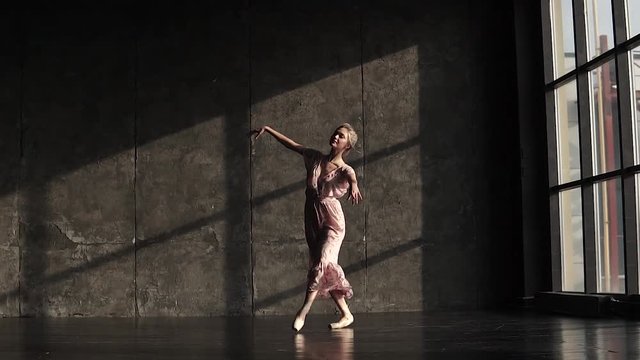 young beautiful ballerina in a long fluttering dress dancing classical ballet. Ballet dancer in pointe shoes. slow motion