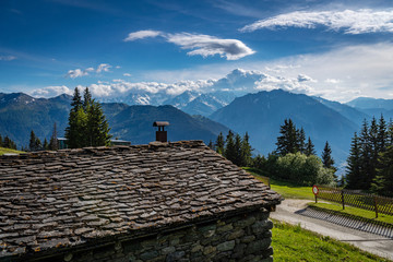 Obraz premium Scenic view of beautiful landscape in Swiss Alps. Fresh green meadows and snow-capped mountain tops in the background in springtime, Switzerland.