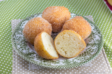 Cut fried curd donuts on a old plate