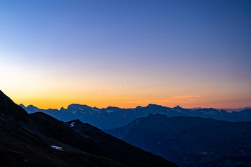 Fototapeta na wymiar Scenic view of beautiful Swiss Alps mountains. Blue hour sunset with pink and blue tones, Verbier, Canton du Valais, Wallis, Switzerland.