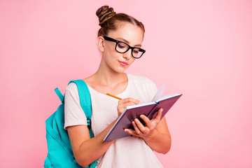 Portrait of concentrated reader student girl writes in notebook 