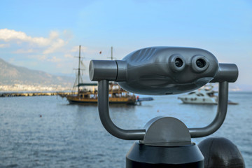 Panoramic binoculars standing on the shore. Ship at sea. Binocular looks at the ships at sea.