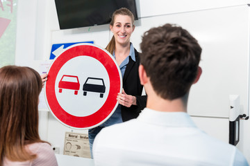 Driving instructor explaining meaning of street sign to class of students