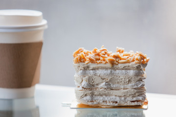 Coffee Meringue Cake on top Almond with disposable cup coffee.