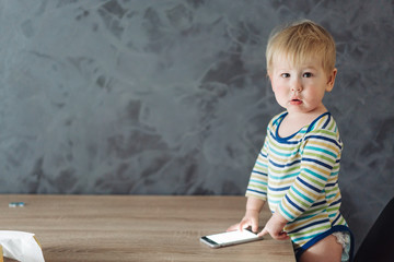 Naklejka premium baby boy standing near the table