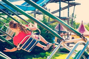 Naklejka premium The girl is riding a carousel at high speed on a swing.