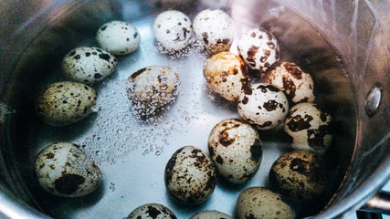 Eggs cooking in water and in a pot, quail eggs