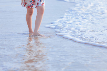 Caribbean vacation travel - woman leg closeup walking on white sand relaxing in beach.