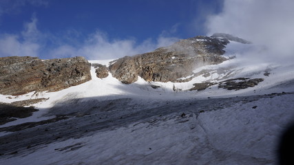 Szlak prowadzący przez topiący się lodowiec schodzący z wysokich gór skalistych w Alpach - masyw Monte Rosa.