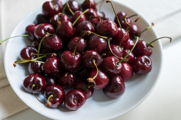Cherries in a white bowl on a white background