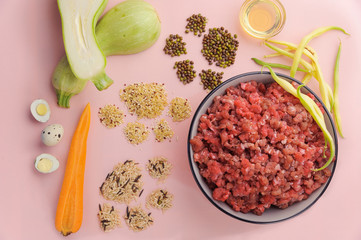Natural raw ingredients for pet food on pink background. Flat lay.