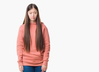 Young Chinese woman over isolated background wearing sport sweathshirt with serious expression on face. Simple and natural looking at the camera.