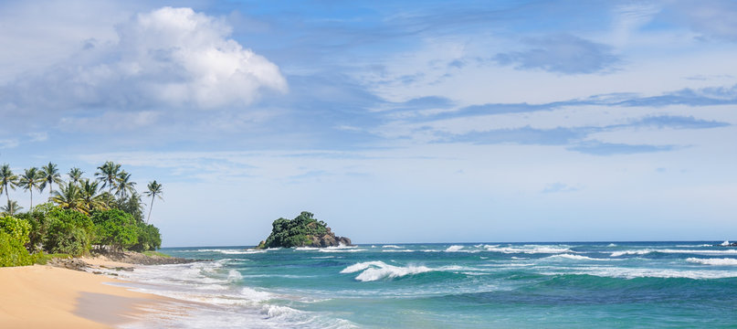 Picturesque beach and blue sky. Coastline of Sri Lanka. Wide photo.