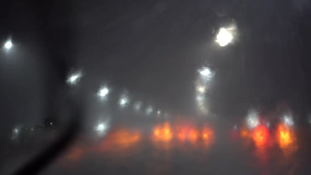 Driving on highway in torrential rain. Hazardous obscured vision due to pouring rain, windshield wipers ineffective in a big rainstorm. Cars driving carefully and slowly in inclement weather.
