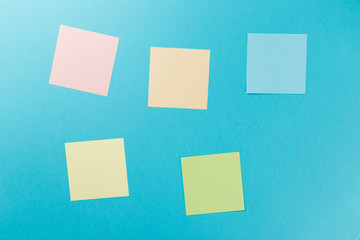 Colorful paper stickers on blue background. Top view. Flat lay. Copy space. Concept. Mock-up lot of color empty office stickers on a blue background