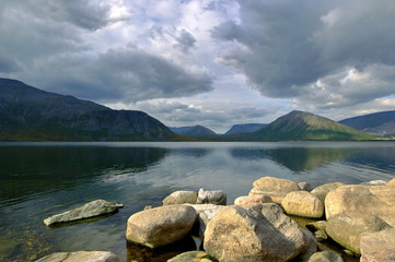 Fototapeta na wymiar Dark gray clouds under lake in mountain